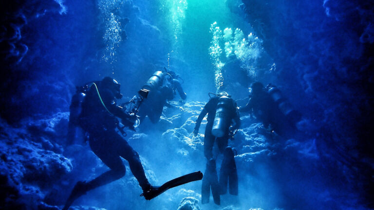 Divers Explore Underwater Cavern